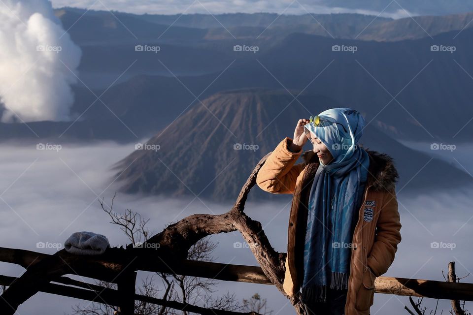 a girl is enjoying the view of Mount Bromo in the morning, the fresh morning air and the rising sun are ready to warm the atmosphere. My instagram: @dodhoy_cikuray