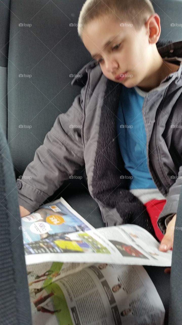 Boy reading newspaper