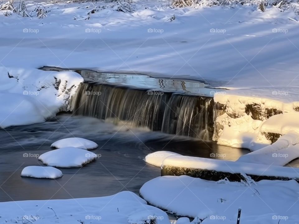 Long exposure effect: winter waterfall in the middle of the frozen water