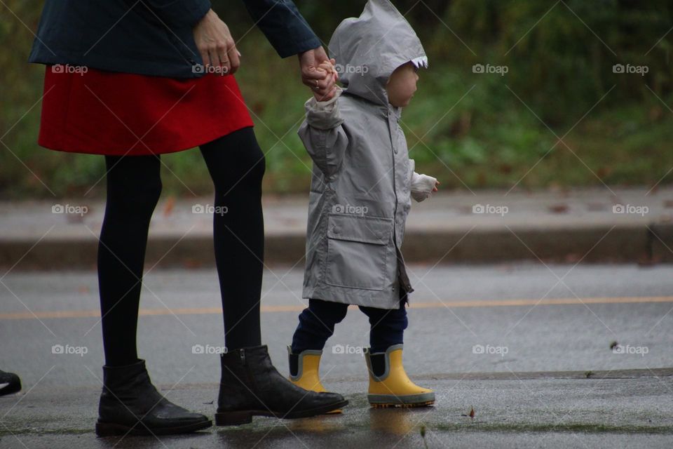 Cute child and his mom outside on a rainy day