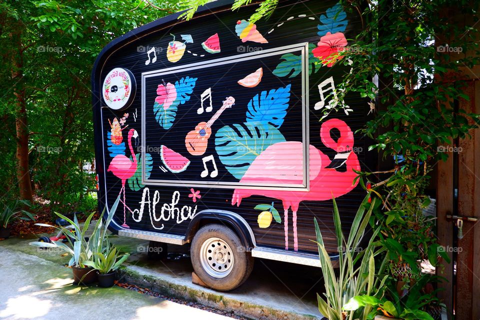 A van-type vending machine that is beautifully painted on the exterior wall.