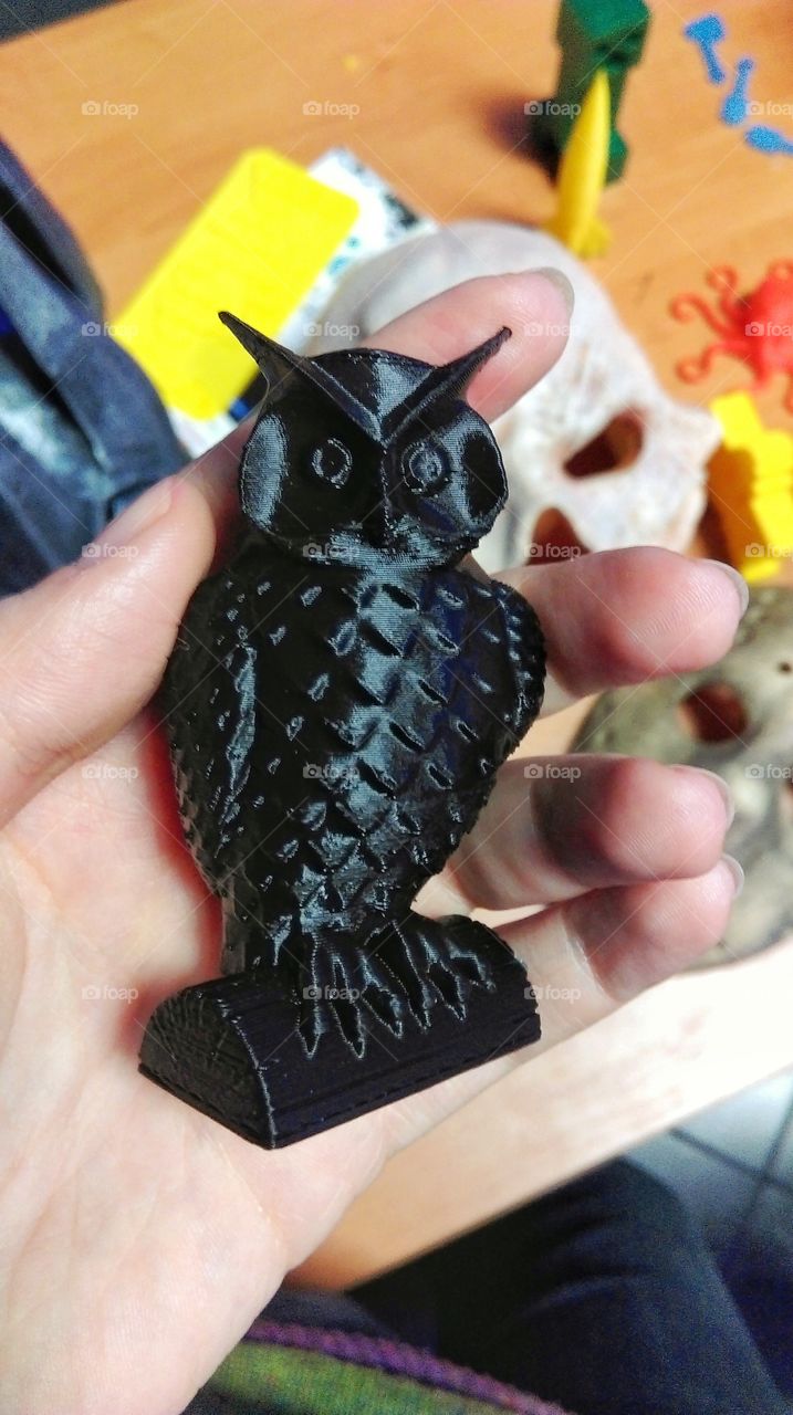 3D printed owl. Hand holding plastic owl printed in 3D