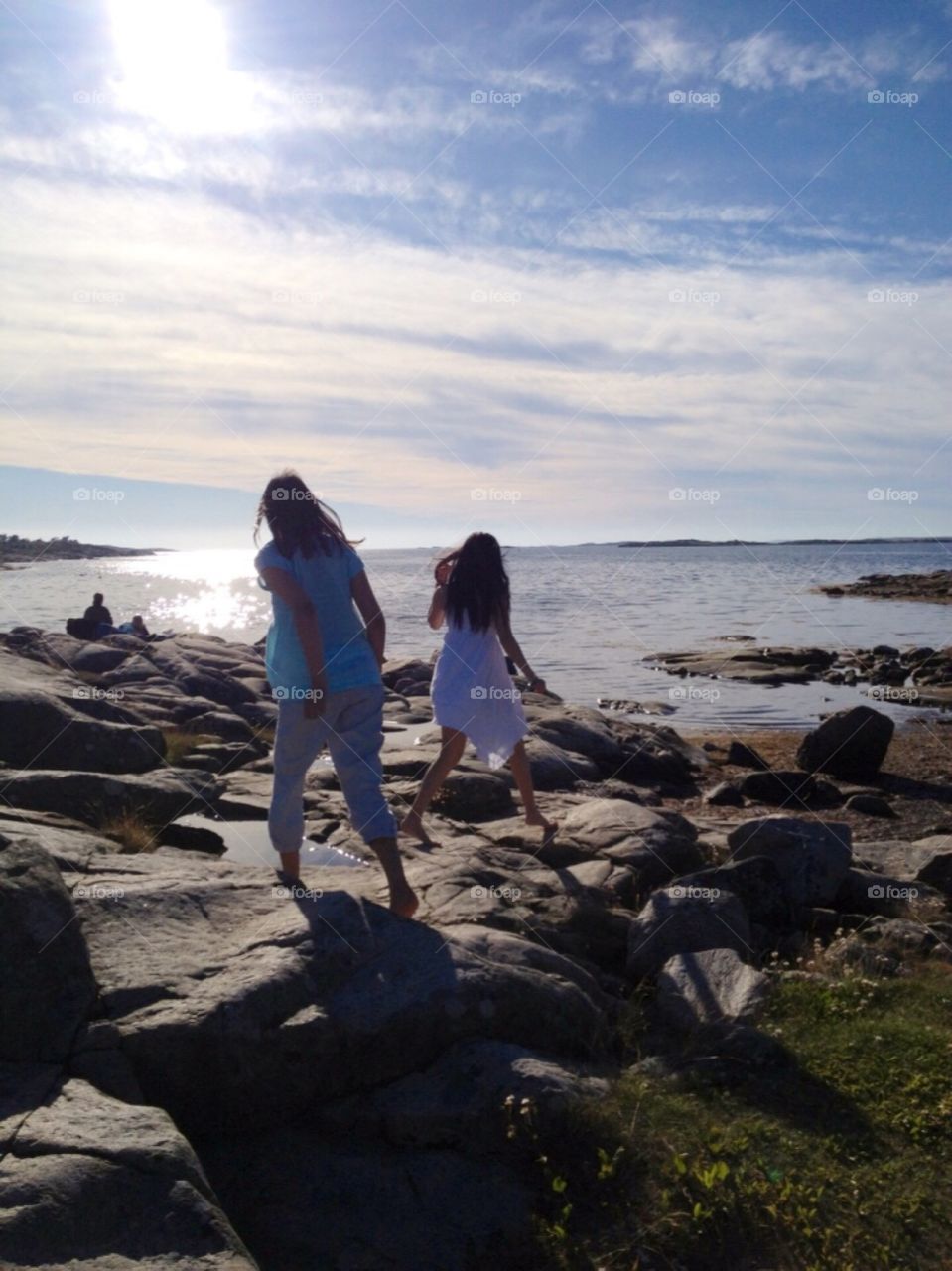 Girls running on the cliffs towards the sea