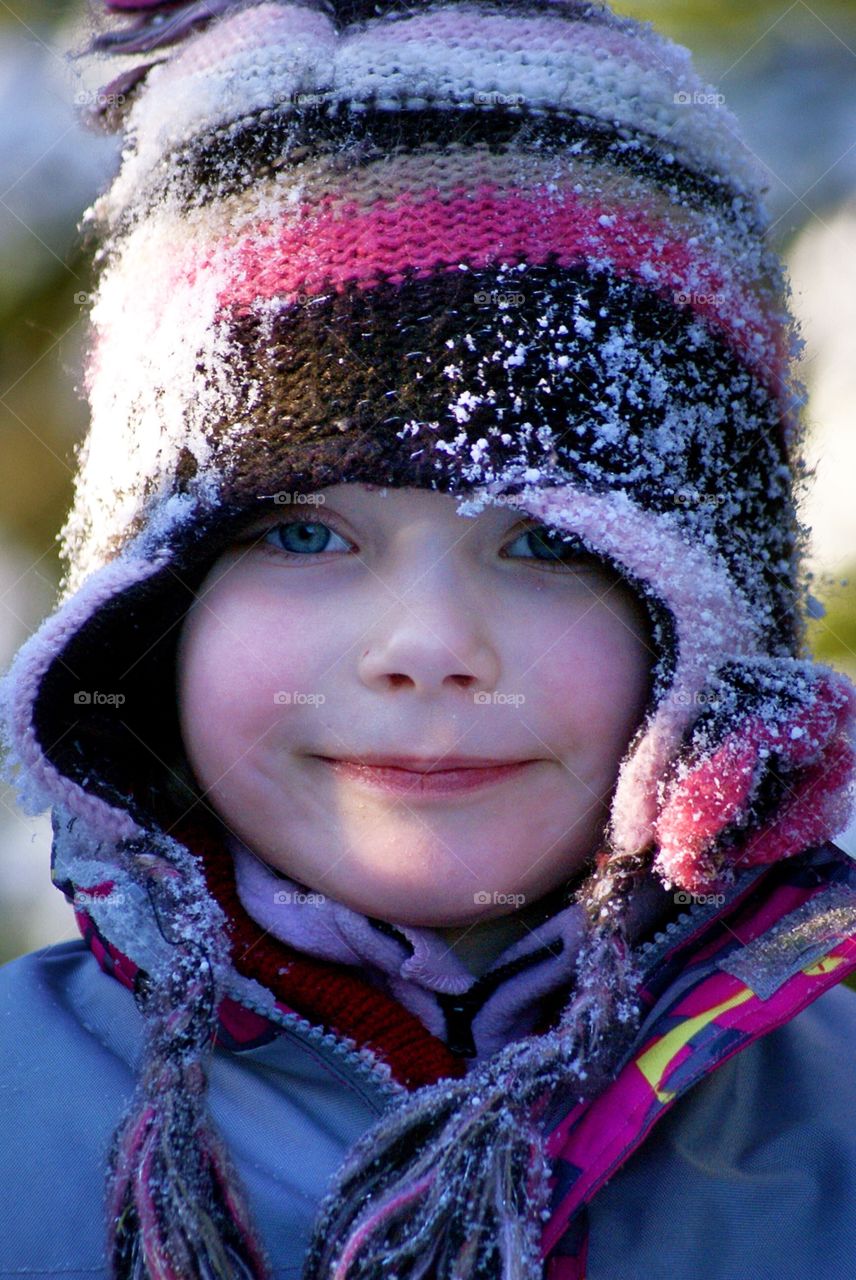 Cute girl in a snowy hat