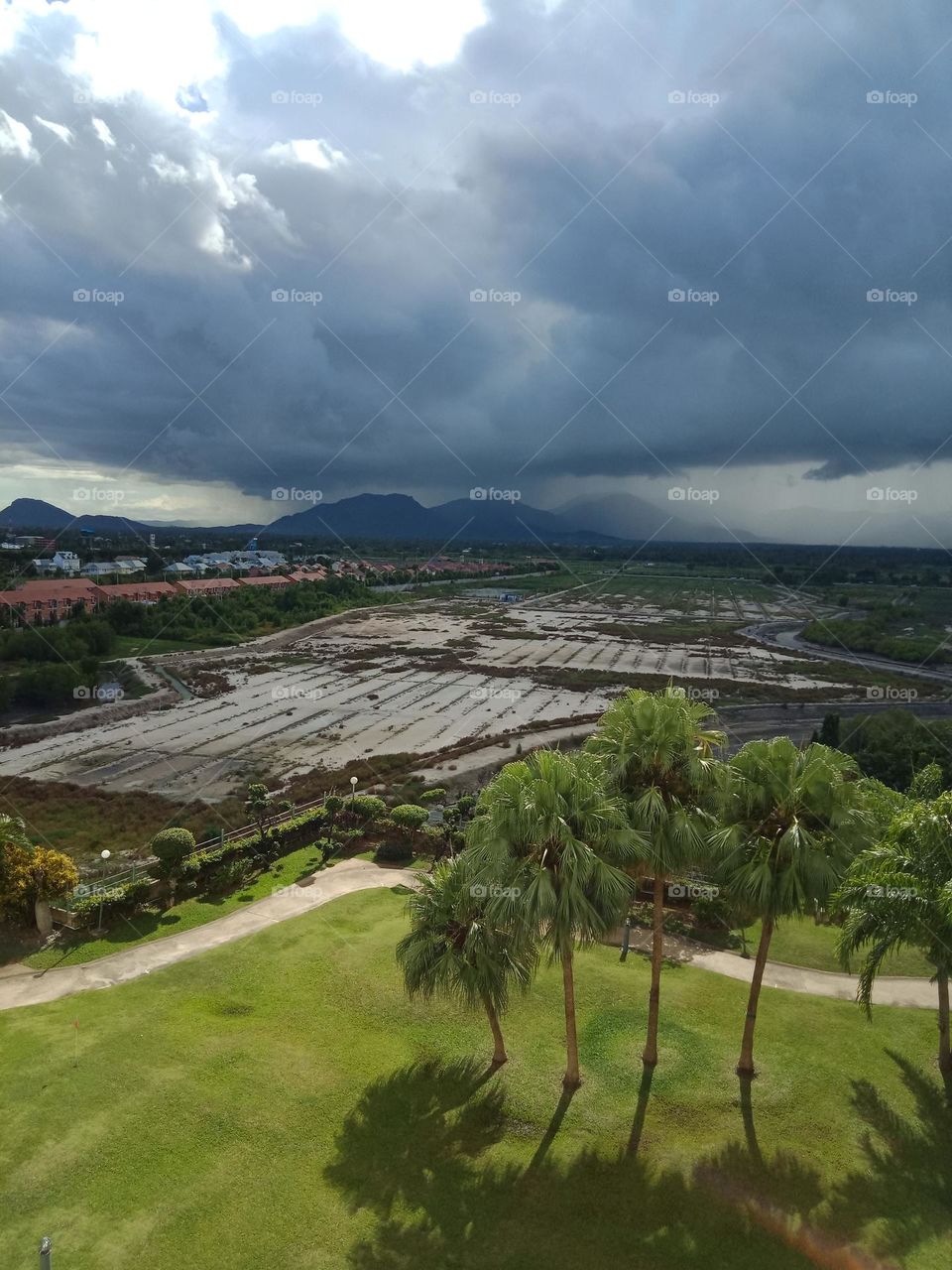 Sunny green VS grey rain clouds