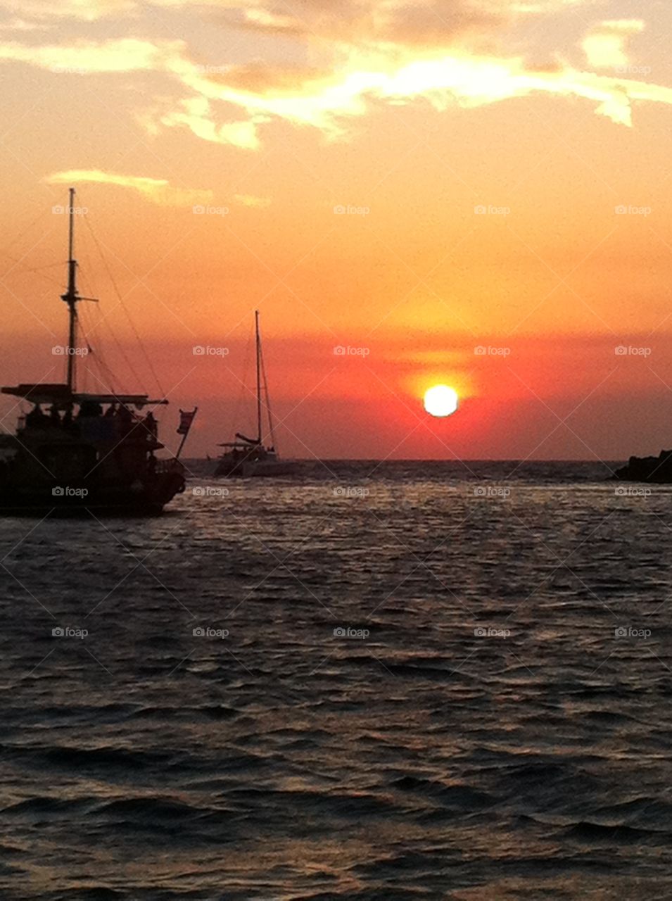 sunset behind sailing ship
