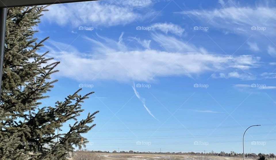 The baby blue of this sky, on a cloudy day, my flying white dragon in the sky with an arrow going through him.