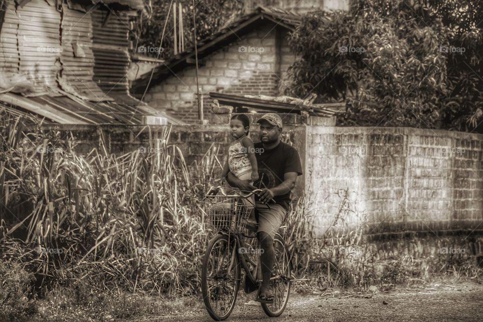 Young father with his little daughter on bicycle
