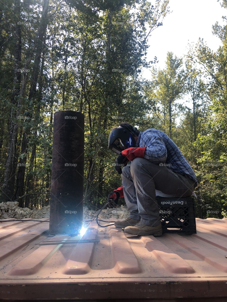 Installing a storm shelter. Man welding venalation turbines
