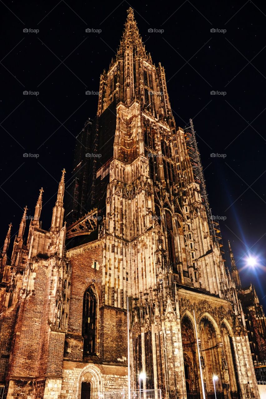 Ulmer Münster unter klarem Sternenhimmel mit Mond im Hintergrund 
