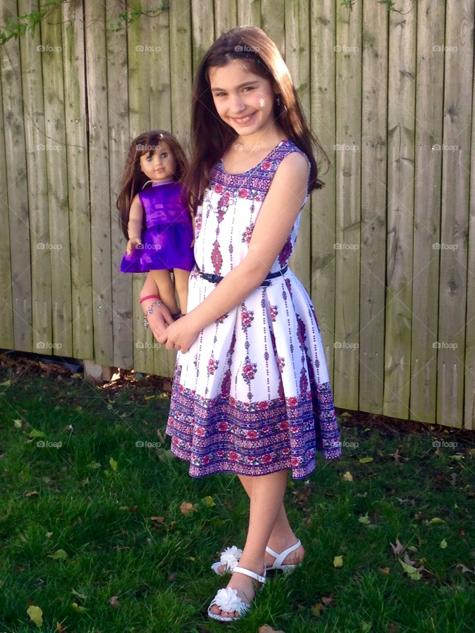 Smiling girl carrying her toy doll