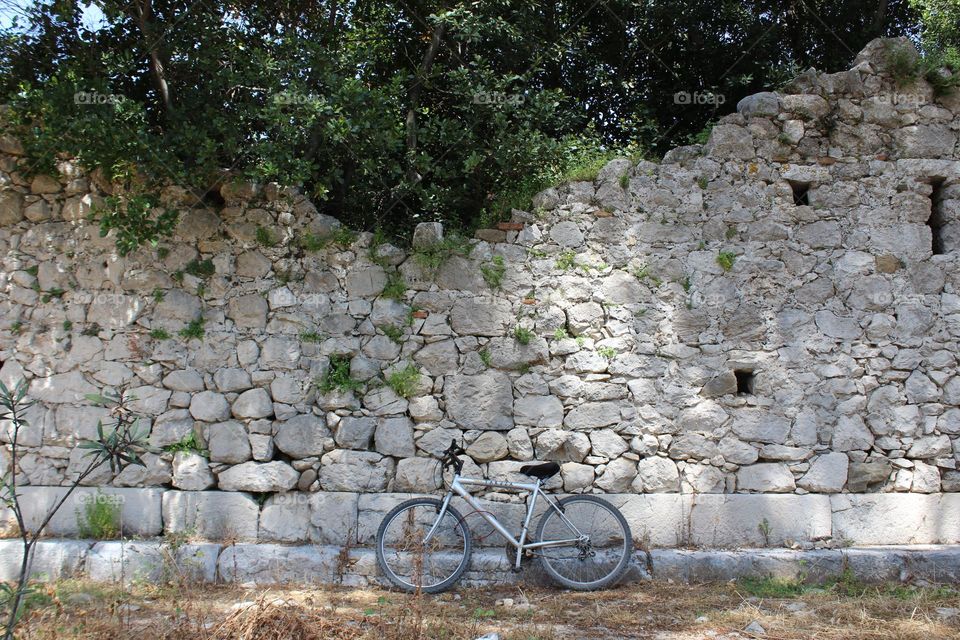 A bicycle parked along an ancient stone wall in Olympos national park, in Turkey.