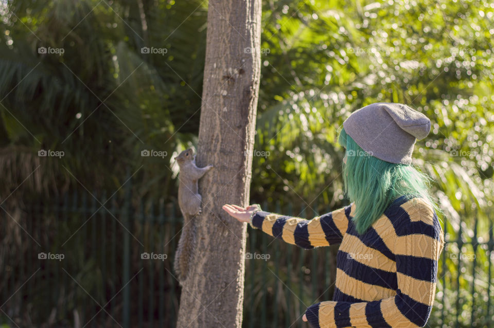 Alternative girl feeding a squirrel