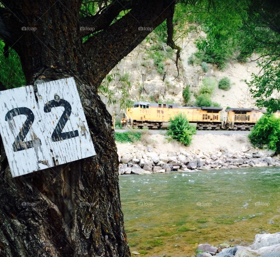 Freight train on tracks along Colorado River in Glenwood Canyon near Glenwood Springs, from campsite number 22 of resort