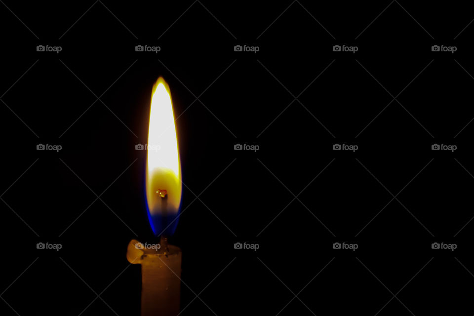 A christmas candle spreading light on black background.