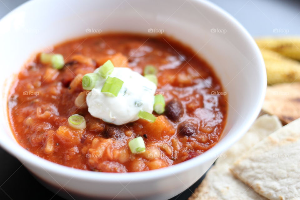 Bowl of chili soup. Chili soup in a white bowl with sour cream garnish 