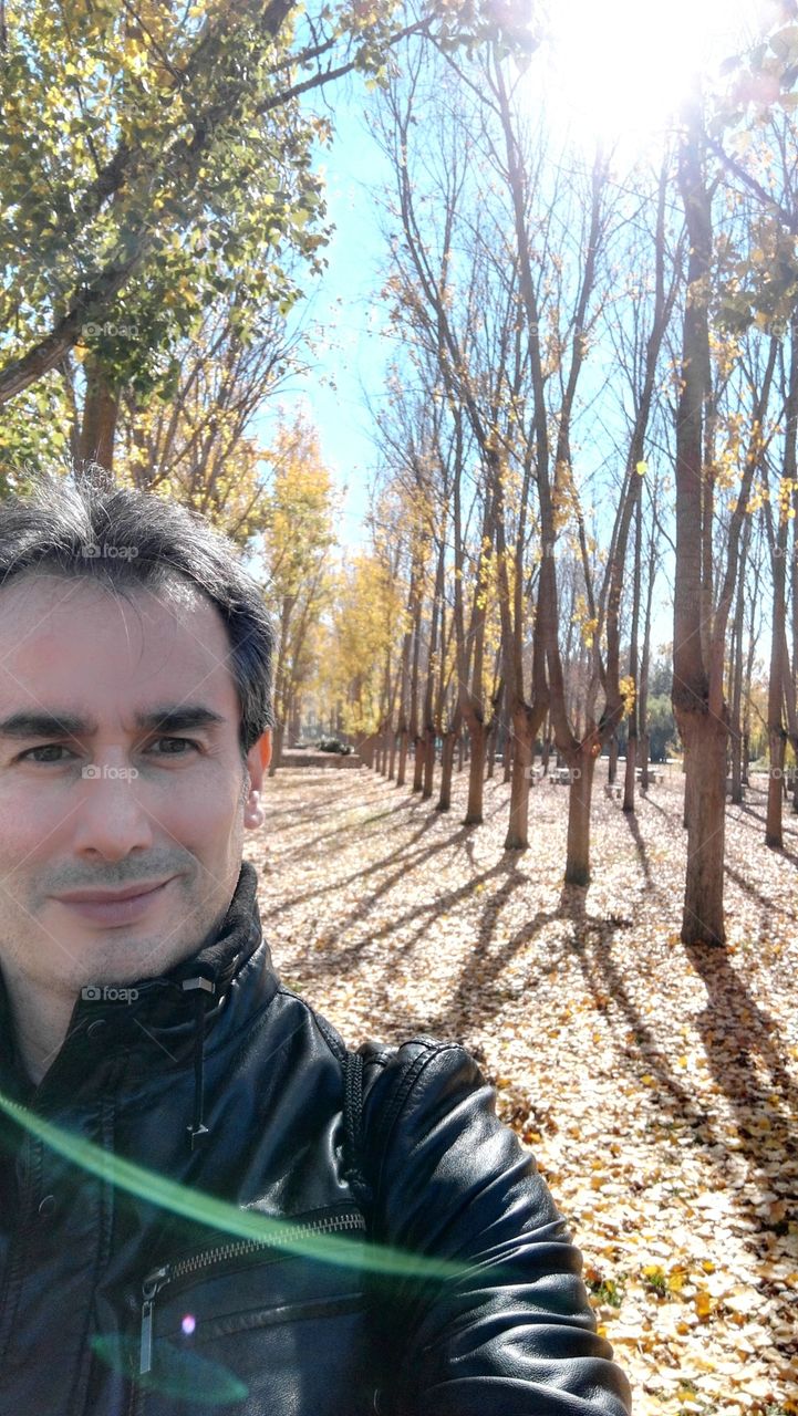 portrait of a man smailing in a field in autumn in a sunny day