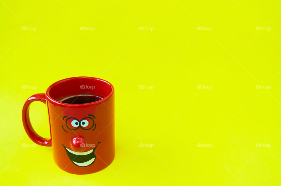 Coffee cup on yellow background with copy space 