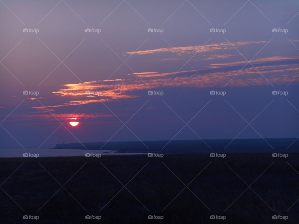 beautiful colorful sunset in the steppe and sea shore summer landscape