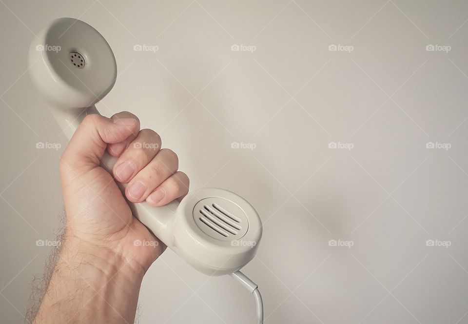 Hand holding old school telephone receiver 1