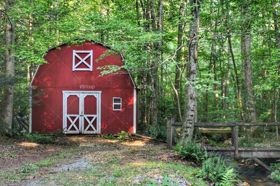 A small farmhouse with a bridge next to it 