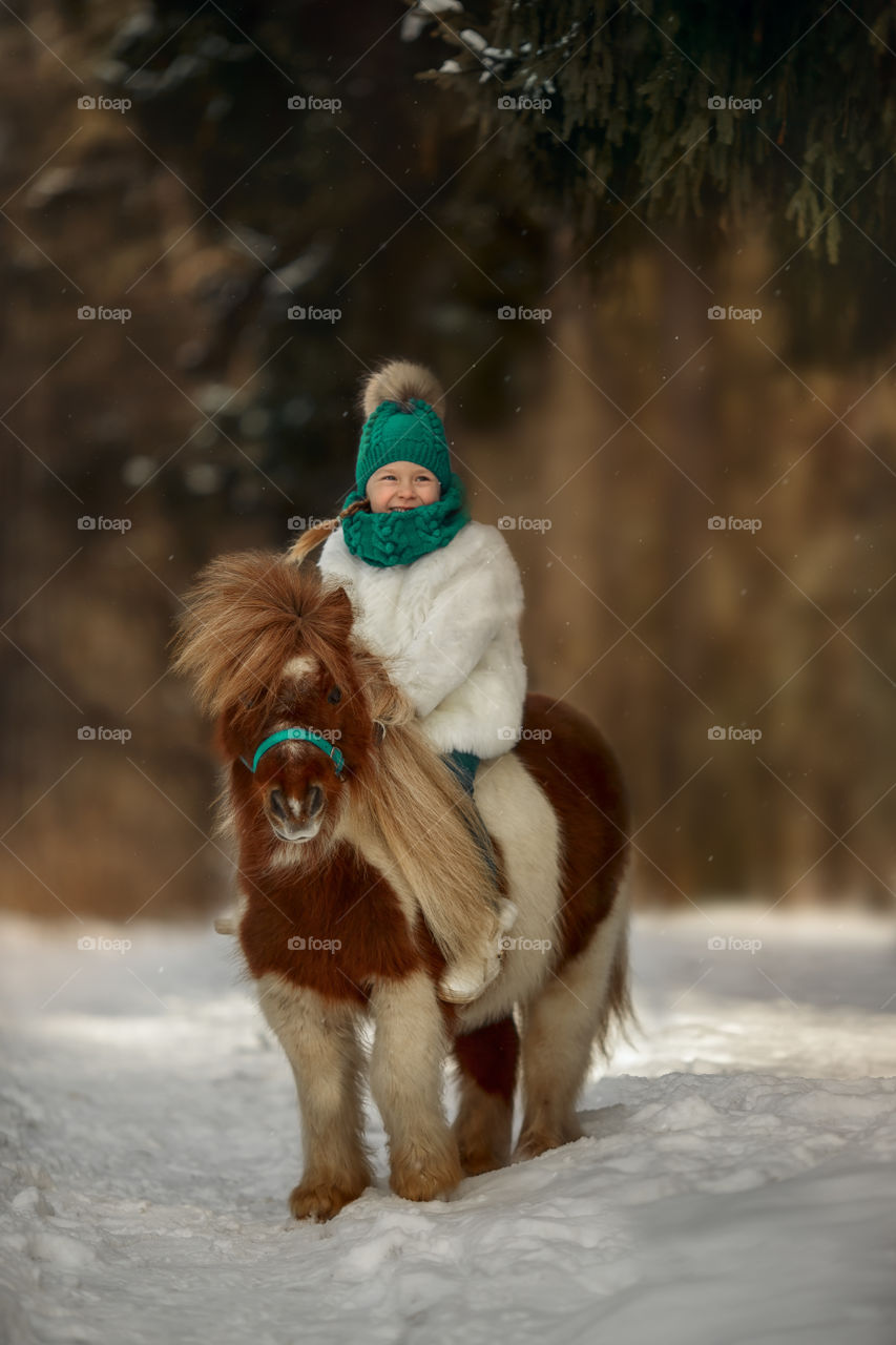 Little girl with pony at early spring day