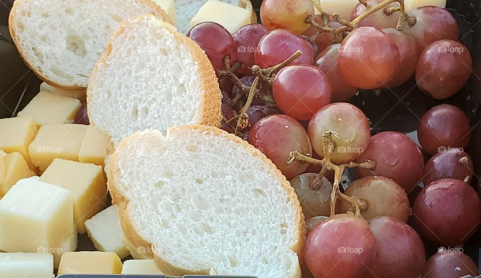 Delicious variety meal of bread cheese and grapes