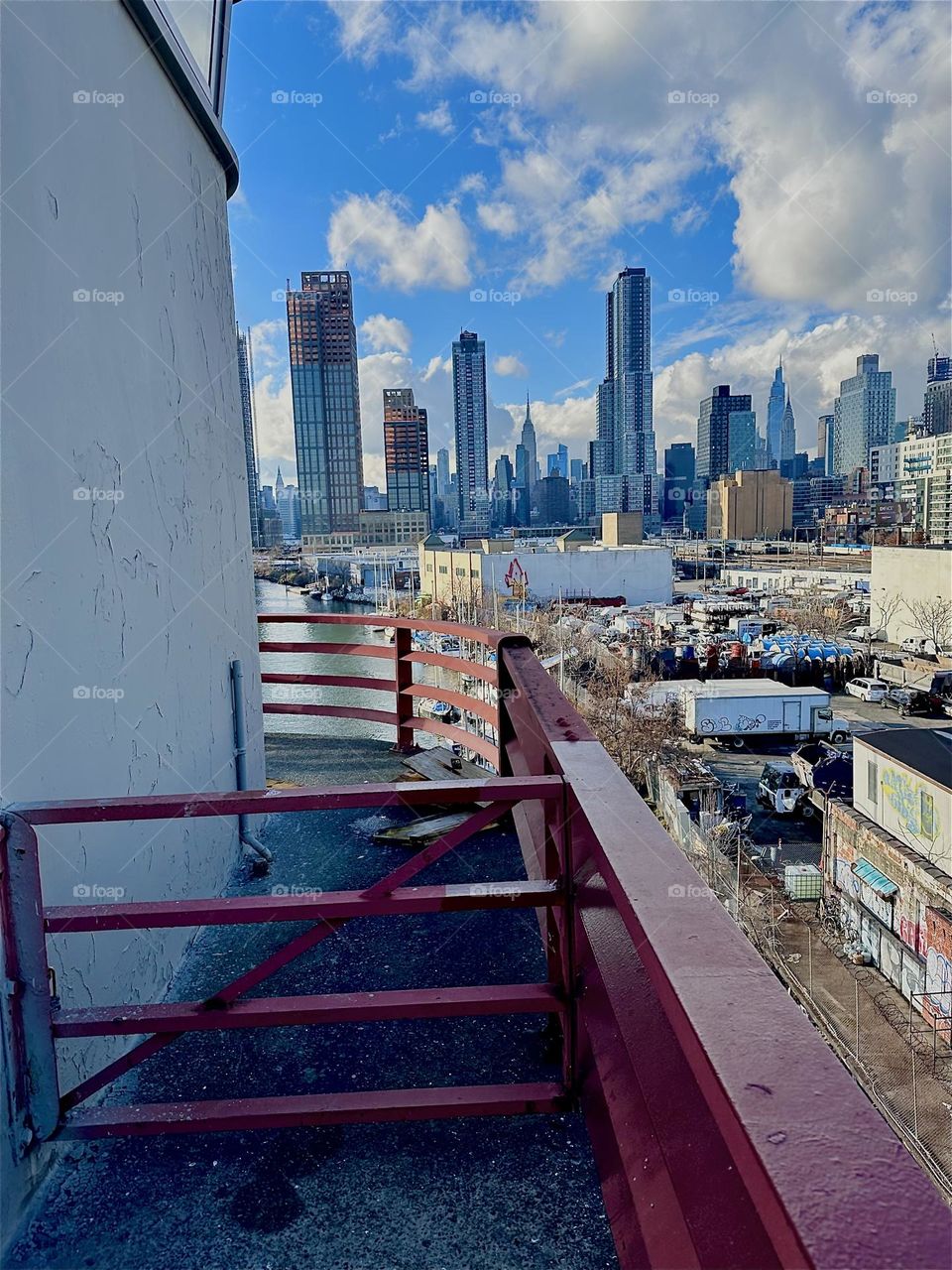 This beautiful panoramic view unfolds from the central outpost of the “Pulaski Bridge” at “Newtown Creek” that connects LIC, Queens to “Greenpoint”, Bklyn. In the distance we see “Manhattan” incl. the “Empire State Bldg”. 2023. Hypnotic Productions