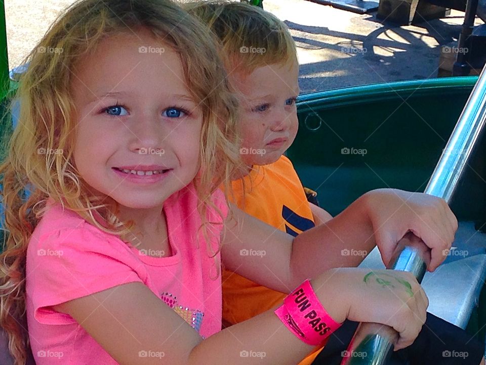 Brother and sister enjoying ride at amusement park