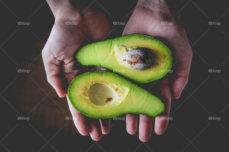 Hands holding avocado