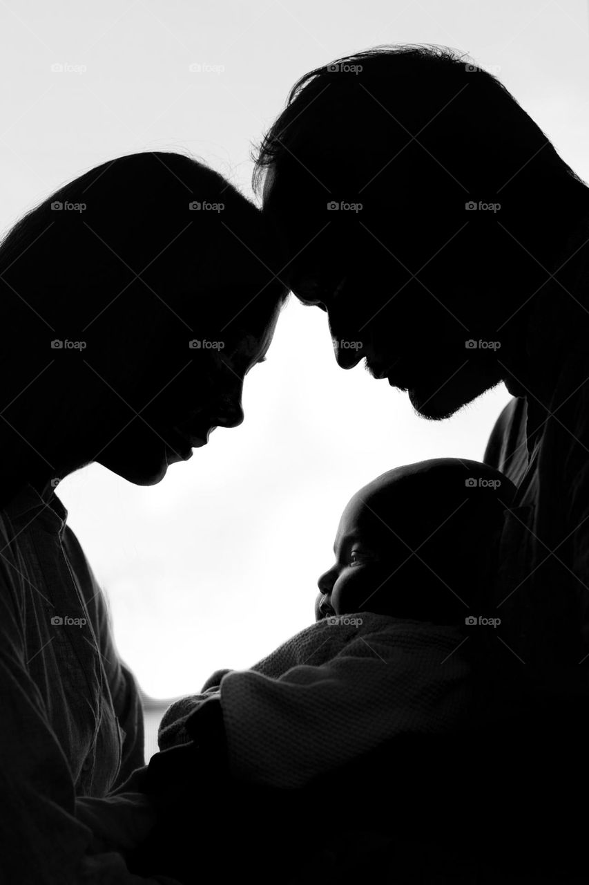 Mom, dad and baby. silhouettes against the background of the window. young parents with a child