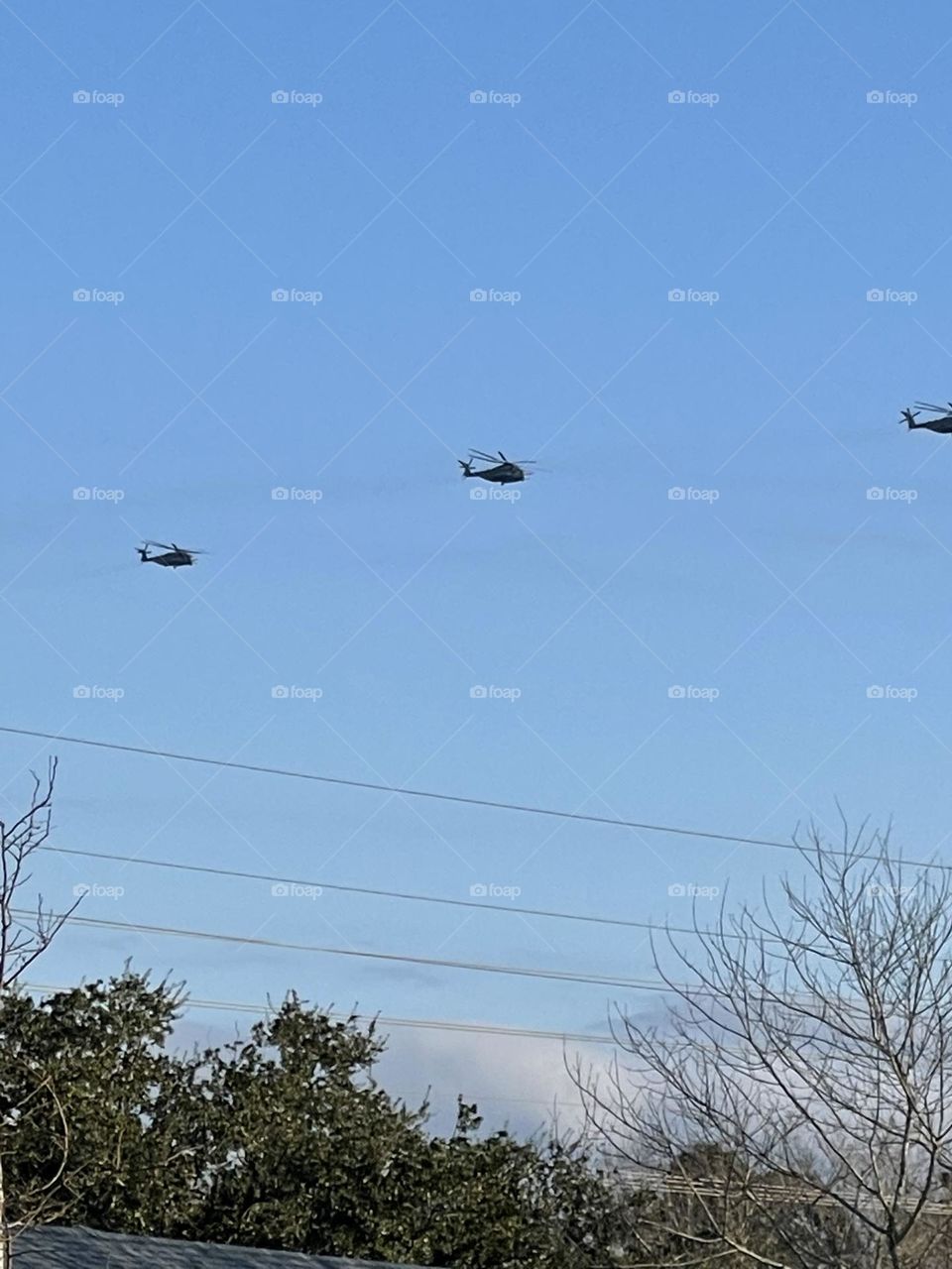 Blue sky with three military helicopters on training mission. 