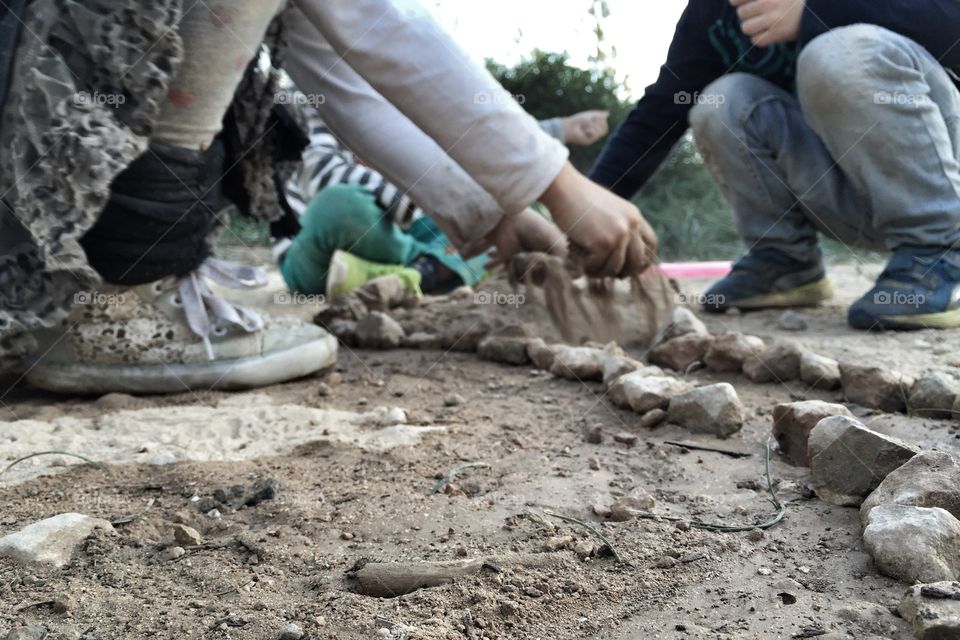Kids playing with rocks and sand