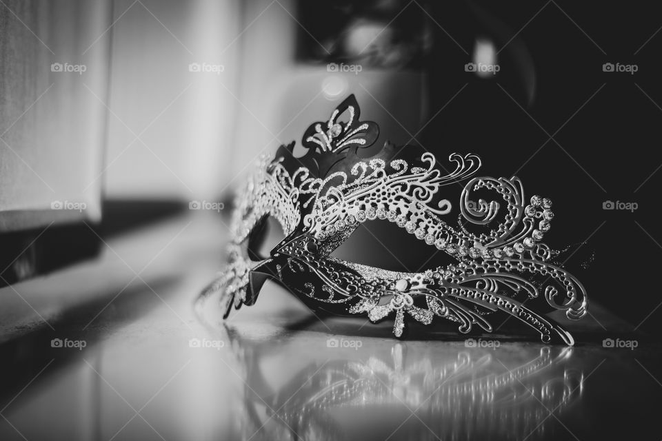 A black and white portrait of a venetian carnaval mask full of mystery, ready to hose someones identity on a masquerade party.