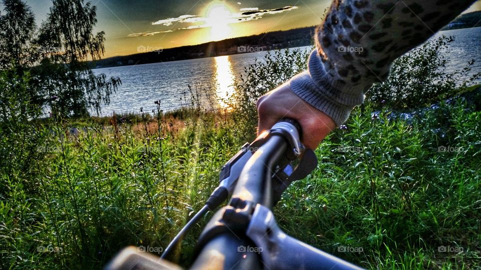 rider by the sea. Riding a bike by the sea near sunset