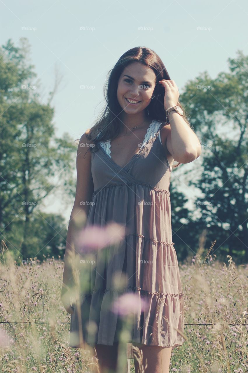 Beautiful smiling woman standing on meadow