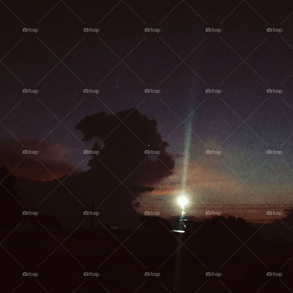 Crack of dawn silhouette and shadows of a Cloud figure floating along in the wee hours of early morning. 