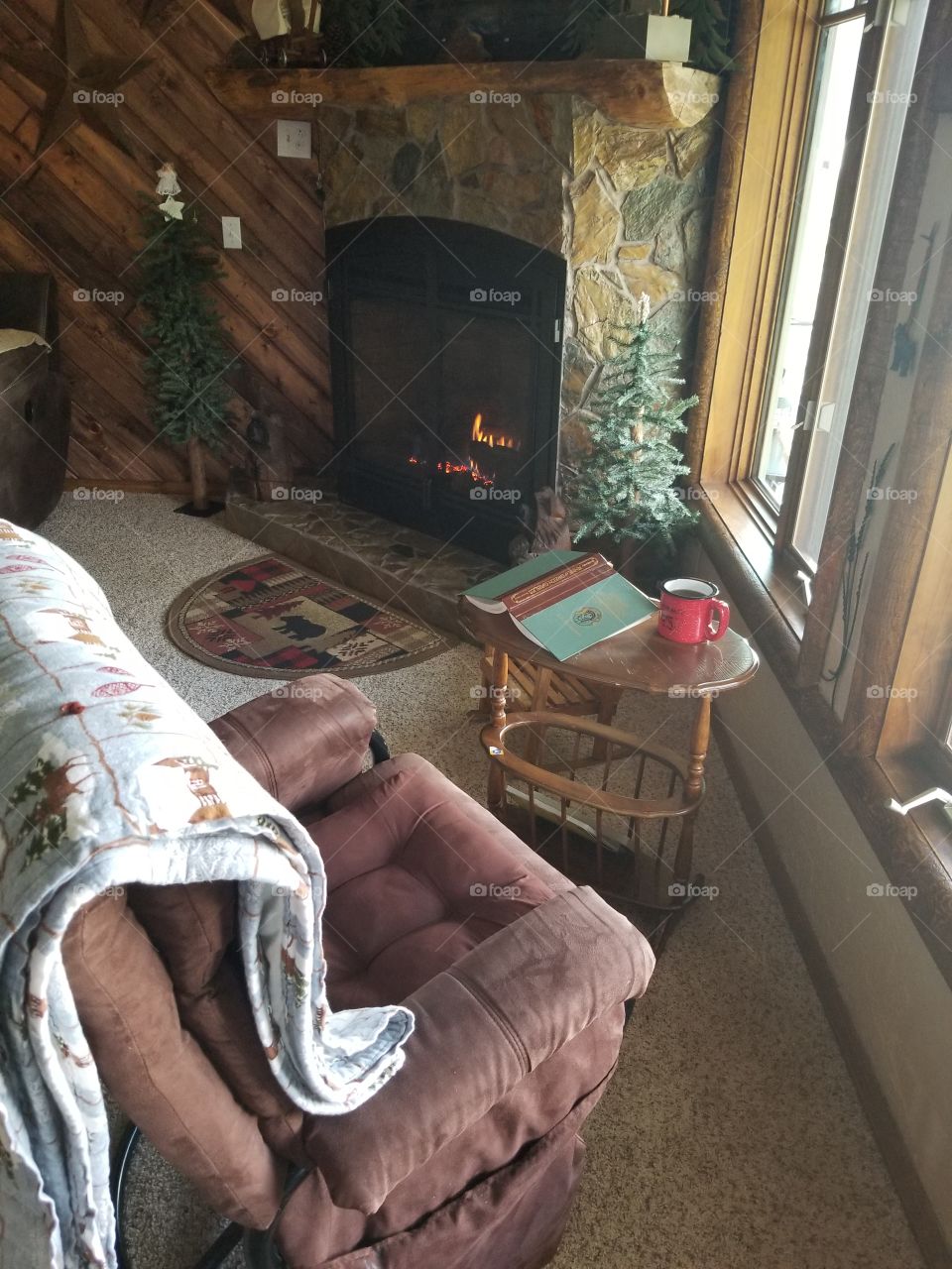 cozy fire, hand laid rock fireplace, recliner,  a homemade quilt,  a classic book and a hot beverage. perfect spot to enjoy reading, nature watching out the window, snow falling or a leisurely conversation with loved ones