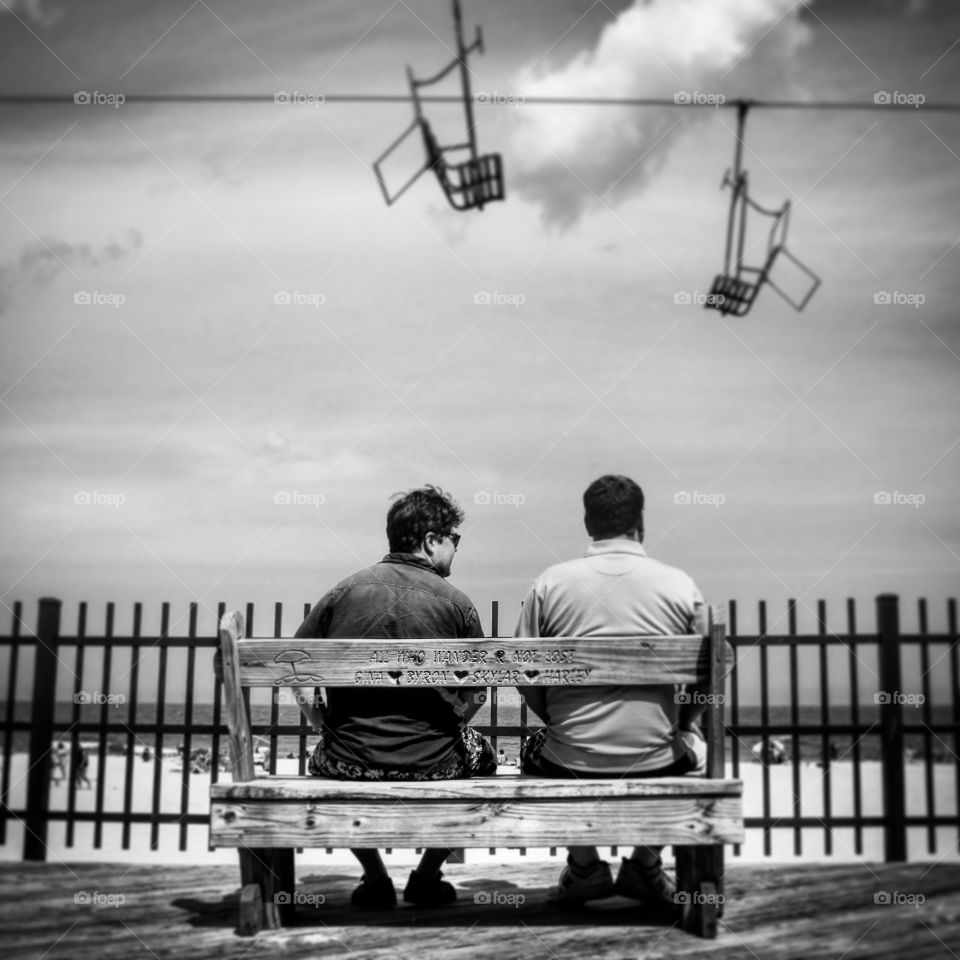 Brothers seating on a bench overlooking the beach