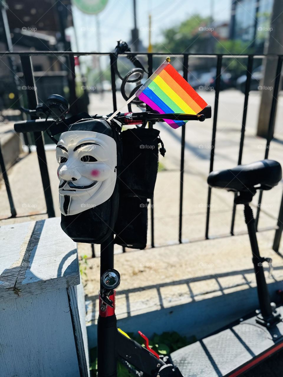 Rainbow small flag at a bike on a big city in day. LGBT symbol, freedom