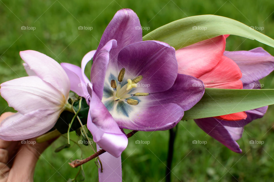 Closeup of woman's hand holding beautiful flower crown outside 