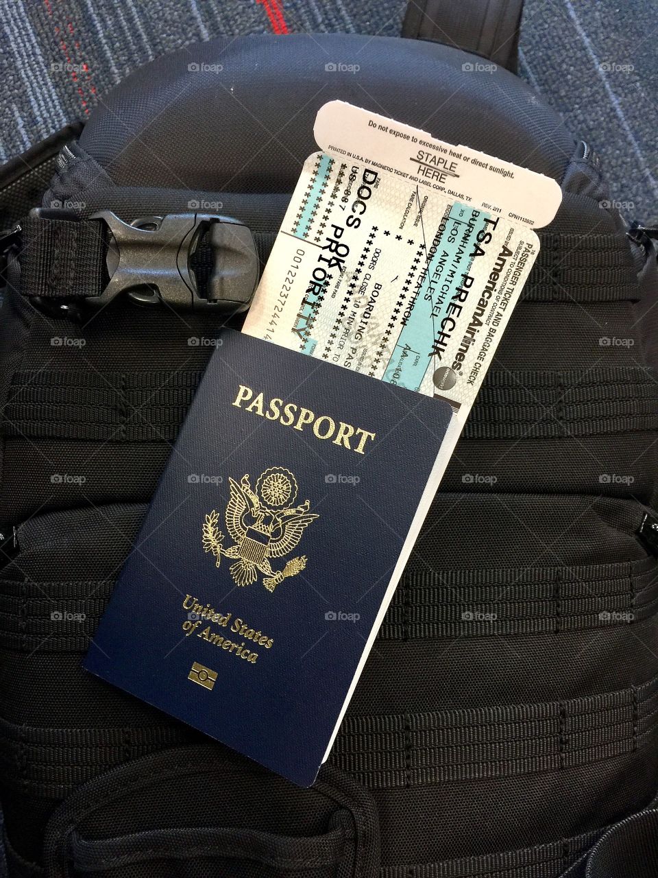 Passport and boarding pass on a carry-on bag waiting to board the airplane for the next flight. 