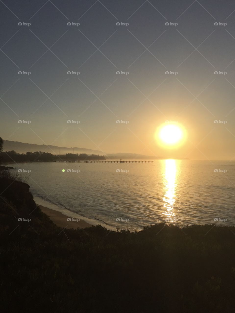 Sun rise at Santa Barbara. Night sun, water, pier. Sun reflecting on water. 