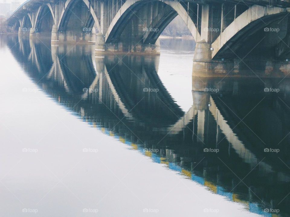 Reflection of the bridge in the Dnieper river