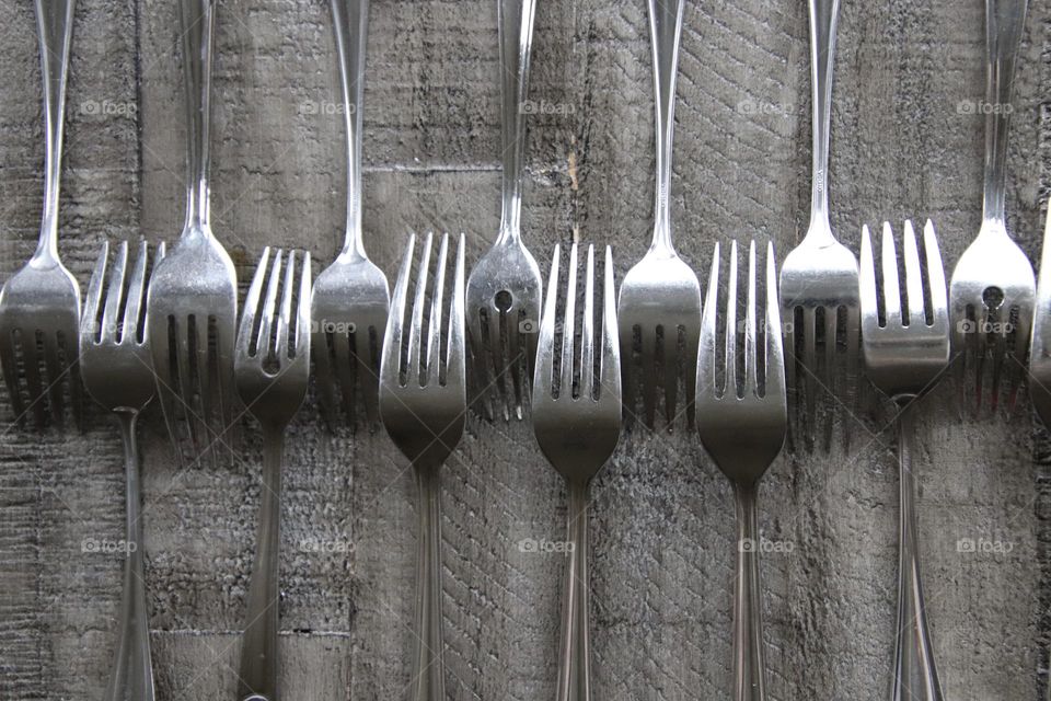 Design made with forks on grey wooden background