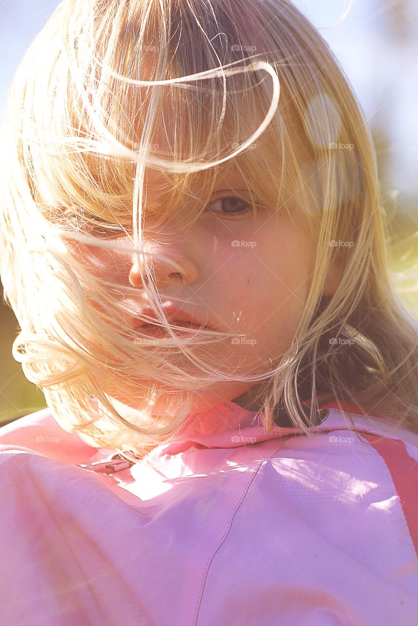 Serious little girl. Serious child a windy day