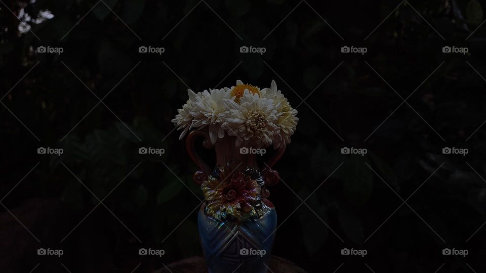 Beautiful white flowers in a colourful flowerpot with a flower sculpture, Flowers in a vase, colourful vase, white flowers in a vase