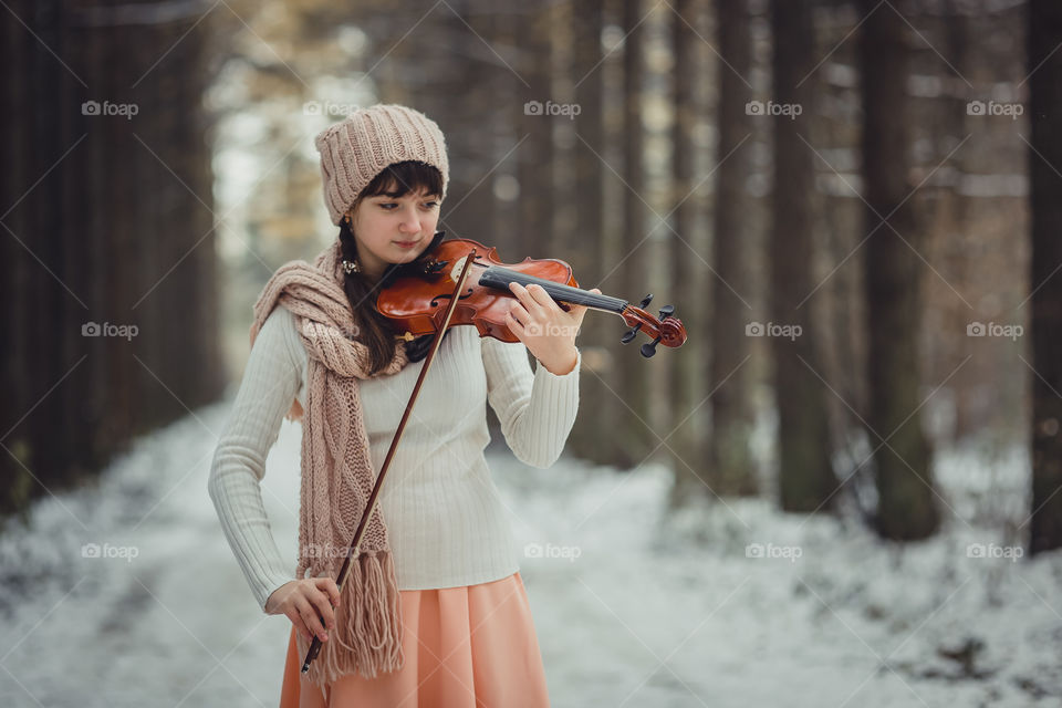 Teenage girl portrait with violin in winter park