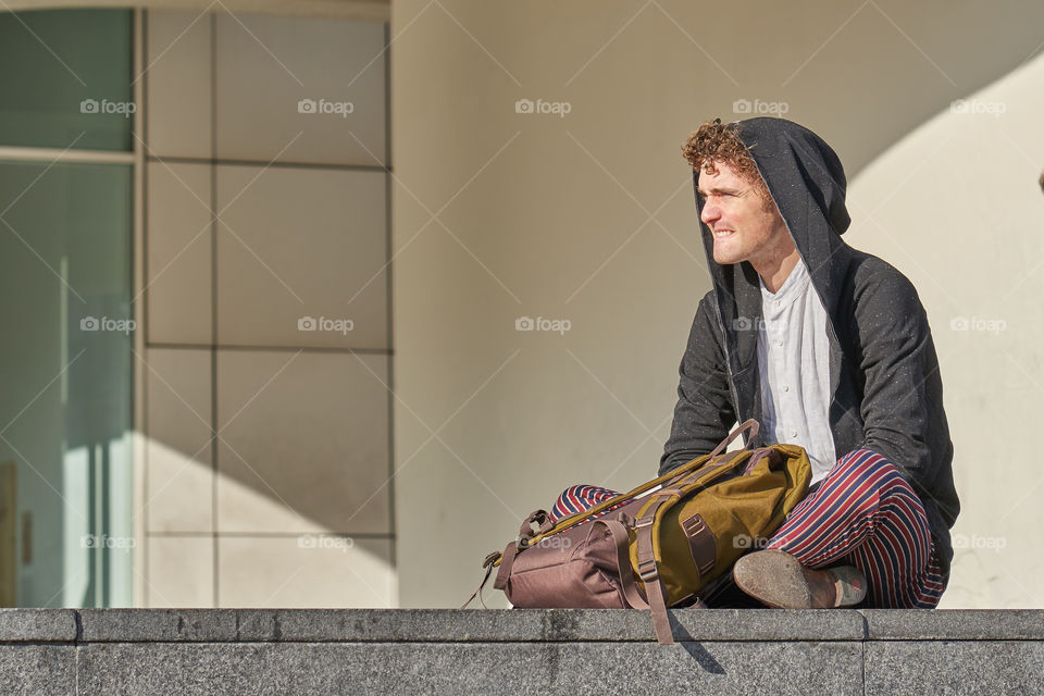 Young man thinking sitting in front of the MACBA