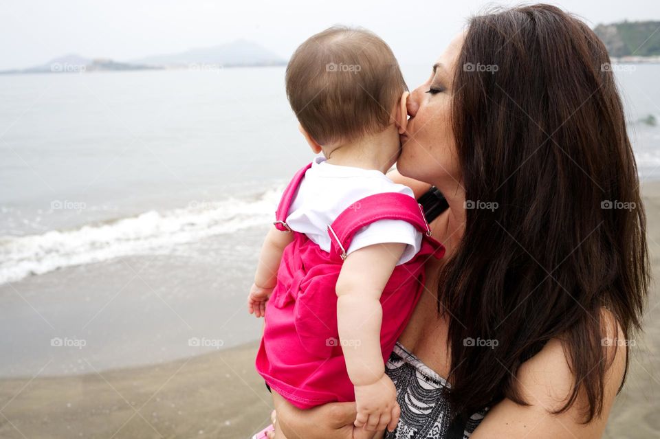 mother kissing her little daughter